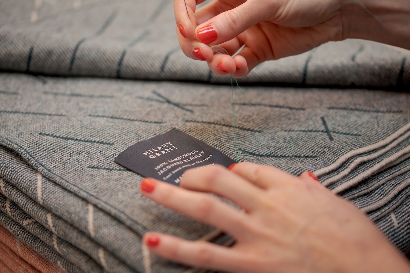 Hand-stitching labels onto the latest Hilary Grant pieces.