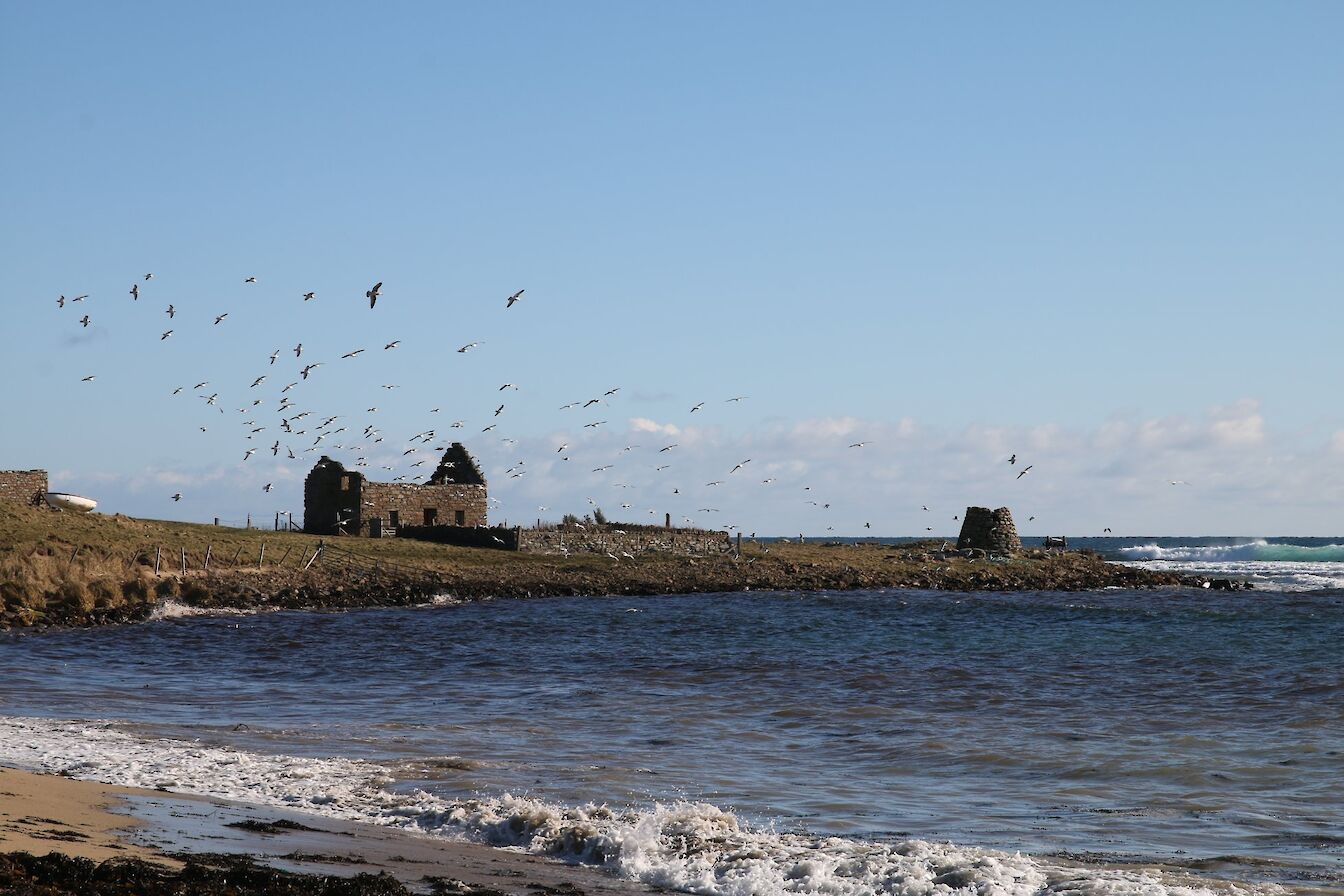 The view towards the remains of an old windmill on the shore